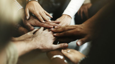 Closeup of diverse people joining their hands